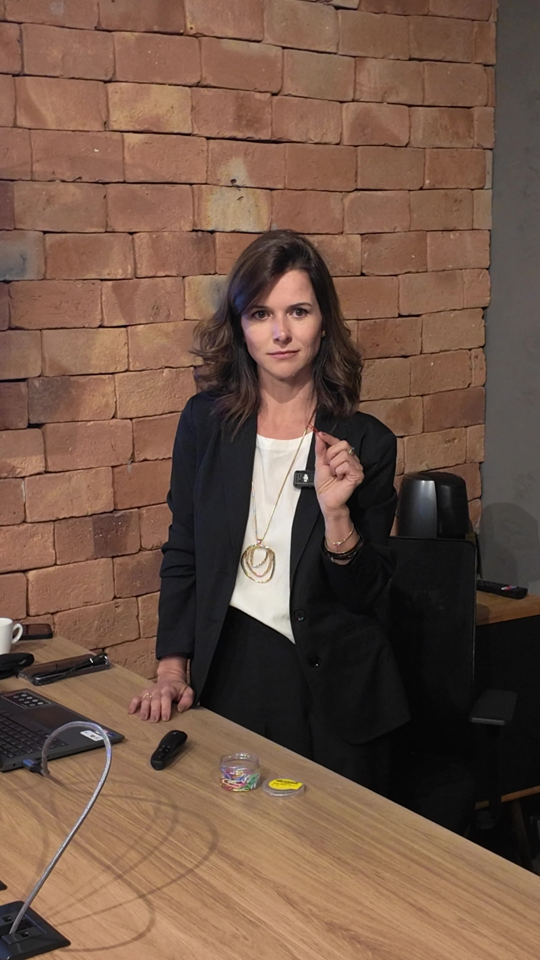Laila Campolina segurando um clipe em seu escritório